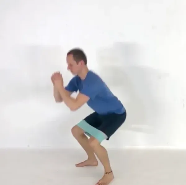 A squat with a short fabric loop band around the thighs